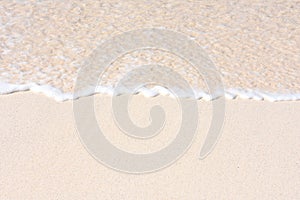 Wave on a sandy beach clear water and white foam