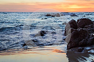 Wave of the sea on the sand beach. Seashore on sunset