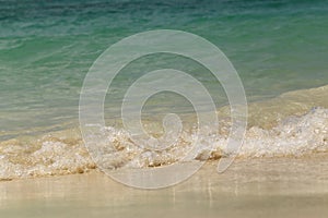 Wave of the sea swashing up onto sand beach, summer background