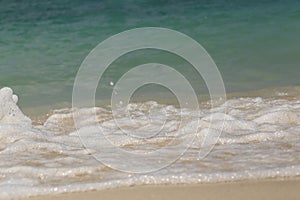 Wave of the sea swashing up onto sand beach, summer background