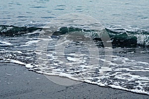 Wave on the shore. Background image in dark colors