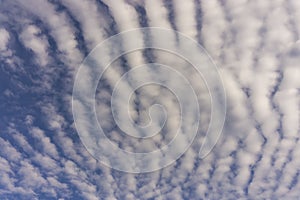 Wave of softy and white fluffy clouds moving with the wind under deep blue sky