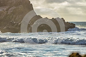 Wave splashes close-up. Crystal clear sea water hitting rock formations in the ocean in San Francisco Bay, blue water, pastel