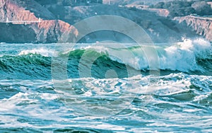 Wave splashes close-up. Crystal clear sea water hitting rock formations in the ocean in San Francisco Bay, blue water, pastel