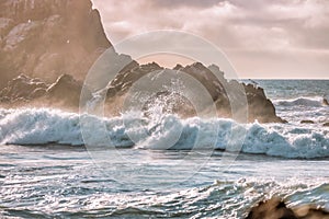 Wave splashes close-up. Crystal clear sea water hitting rock formations in the ocean in San Francisco Bay, blue water, pastel