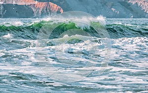 Wave splashes close-up. Crystal clear sea water hitting rock formations in the ocean in San Francisco Bay, blue water, pastel