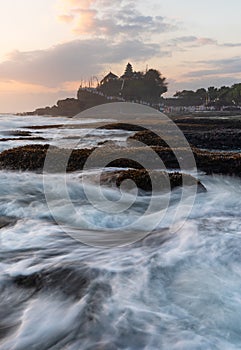 Wave and Tanah Lot Temple in Bali, in sunset