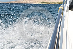 Wave traces from side of the boat on the blue ocean surface with copy space