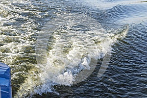 Wave trail from a boat engine on the water. Trail on water surface behind of fast moving motor boat