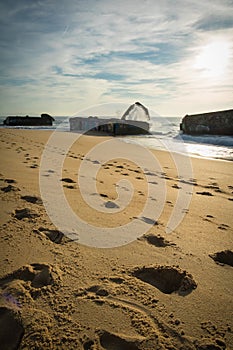 Wave water splash behind blockhouse on scenic beautiful sandy beach seascape with splashing waves