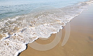 Wave and white form along the beach