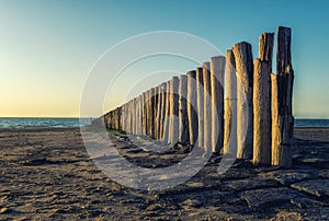 Wavebreakers at low tide and sunset