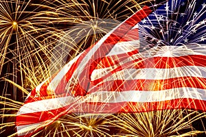 Waved American flag against fireworks in night sky