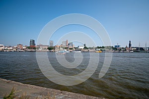 Waveless calm water surface and Hamburg harbor skyline with modern buildings along the Elbe river