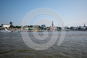 Waveless calm water surface and Hamburg harbor skyline with modern buildings along the Elbe river