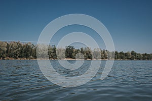 Waveless calm water surface with landscape view on the horizon