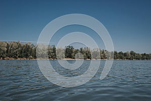 Waveless calm water surface with a landscape view on the horizon