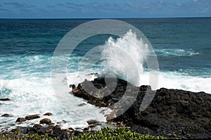 Waves against black lava rock in hawaii