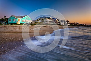 Waves in the Atlantic Ocean and beachfront homes at sunrise, Edisto Beach, South Carolina.