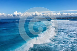 Waves and azure water as a background. View from high rock at the ocean surface. Natural summer seascape. Water background.