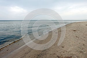 Waves of the Baltic Sea in the Gulf of Riga in Jurmala on empty beach on a dull day in low season