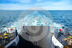 Waves behind the boat that was sailing on the blue sea.