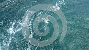 Waves behind a motor boat on an azure water surface when travelling on a vacation