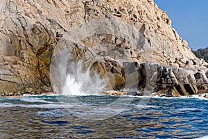 Waves and blow hole on rocks