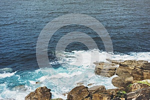 Waves of blue ocean fight about stony coast landscape. Background sea scape. Panorama horizon perspective view nature stone