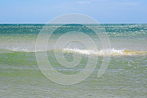 Waves, blue sea and clear sky. Blue sky leaving for horizon above a blue surface of the ocean.