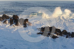 Waves breaking and crushing on the rocks on the Atlantic Ocean on coastline and seashore of Madeira Island , Portugal