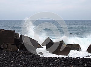 Waves breaking over concrete cubic sea defenses in tenerife