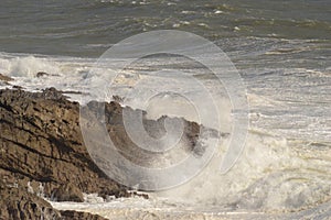 Waves breaking over rocks near Mumbles, Wales, UK