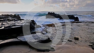 Waves breaking on rocks close to Sandy beach, Oahu, Hawaii