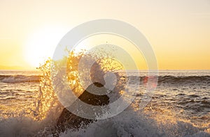 Waves breaking on the rocks of the coast at sunset