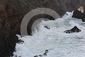 Waves breaking on the rocks of rugged Atlantic Ocean coast in Madeira Island, Portugal