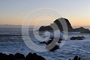 Waves breaking on the rocks of rugged Atlantic Ocean coast in Madeira Island, Portugal at sunrise