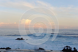 Waves breaking on the rocks of rugged Atlantic Ocean coast in Madeira Island, Portugal at sunrise