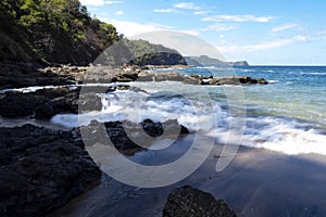 waves are breaking on the rocky Pacific coast. Costa Rica