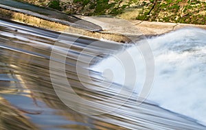 Waves crash as they rebound from a gentle man-made waterfall