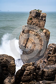 waves crash into a rocky outcropping in the ocean