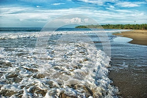 Waves crash on the shore of Manzanillo Beach in Limon, Costa Rica