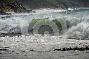 Waves crash on to the rocks and beaches of a cornish coastline,