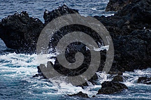 Waves crashing against volcanic rocks in Porto Moniz, Madeira Portugal