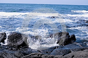 Waves crashing on the beach, basalt on Jeju Island photo
