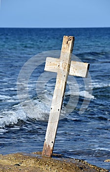 Waves Crashing Behind a Crooked Wooden Cross
