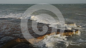 Waves crashing on the cliffy coastline in Portland, England,