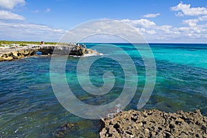 Waves crashing on El Mirador, with tourists in Cozumel, Mexico photo