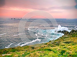 Waves crashing at Land\'s End, England at sunset