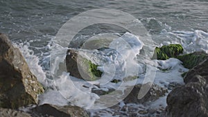 Waves crashing on moss covered rocks